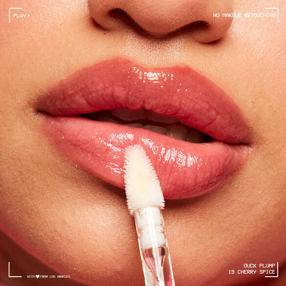 Close-up of lips being applied with a lip gloss wand, showcasing a glossy finish in a cherry spice shade.
